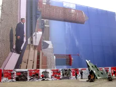Panneau occultant les travaux de la gare montrant une photo de la tour Part-Dieu mise à l'horizontale avec un homme en costume devant elle.